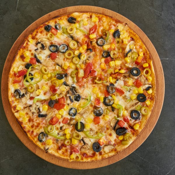 Delicious vegetable pizza topped with mushrooms, olives, corn, and colorful peppers.